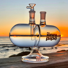 Load image into Gallery viewer, Glass pipe with 'jinni pipe' branding against a sunset ocean backdrop